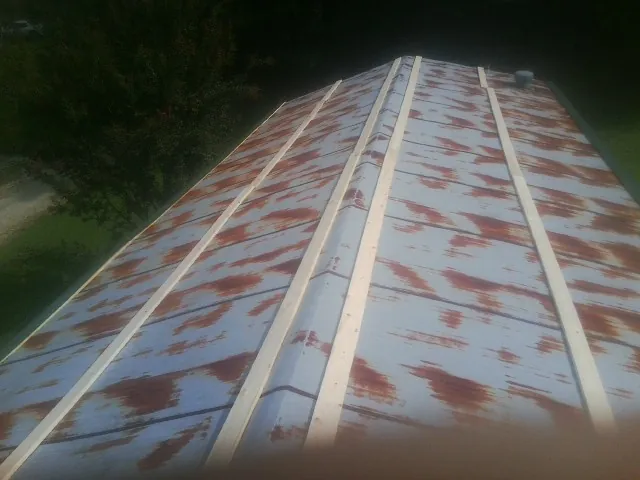 Rusted metal roof panels with new wood purlins before replacement — Storm Damage Roof Repair in Kitty Hawk by Roofing Brothers
